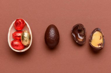 Kahverengi arka planda çikolatalı Paskalya yumurtası ve şekeri.