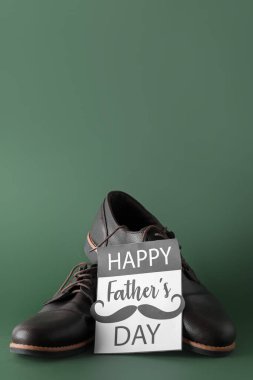 Yeşil zemin üzerinde ayakkabılar olan Babalar Günü kartı.