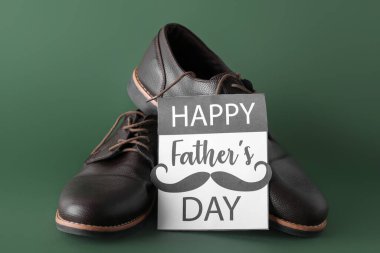 Yeşil zemin üzerinde ayakkabılar olan Babalar Günü kartı.