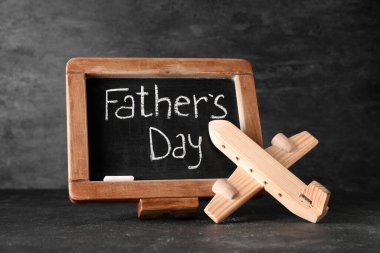 Üzerinde Babalar Günü yazılı yazı tahtası ve arka planda ahşap uçak