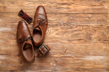 Papyonlu erkek ayakkabılar ve tahta arka planda kemer. Babalar günü kutlaması.