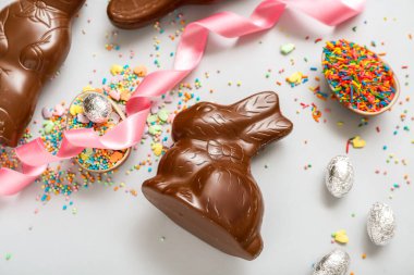 Çikolatalı Paskalya yumurtaları ve mavi arka planda tavşanlar.