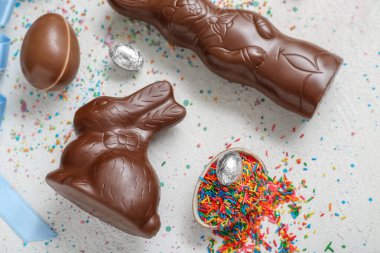 Çikolatalı Paskalya yumurtaları ve gri arka planda tavşanlar.