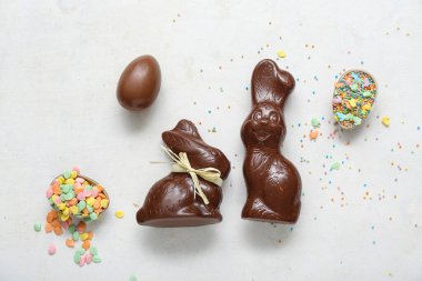 Çikolatalı Paskalya yumurtaları ve beyaz arka planda tavşanlar.