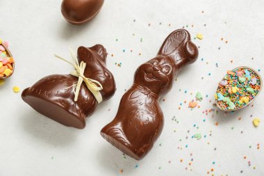 Çikolatalı Paskalya yumurtaları ve beyaz arka planda tavşanlar.