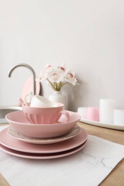 Mutfak tezgahında orkide çiçekleri olan temiz tabak ve vazo, yakın plan.