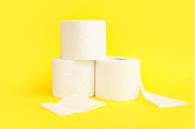 Sarı arka planda tuvalet kağıdı ruloları