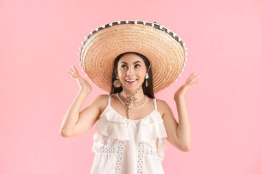 Pembe arka planda şapkalı güzel kadın.