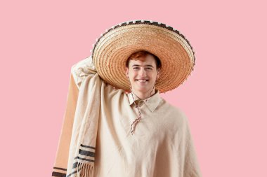 Pançolu genç Meksikalı adam portresi ve pembe arka planda sombrero.