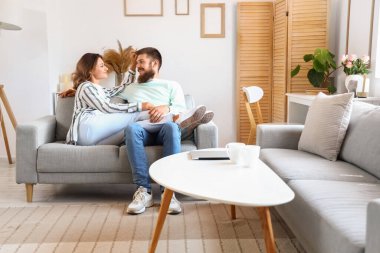 Mutlu çift evdeki kanepede oturuyor.