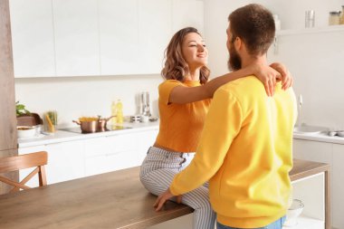 Mutlu çift mutfakta birbirine sarılıyor.