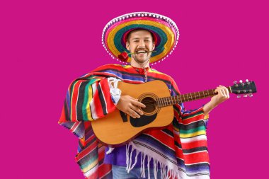 Genç Meksikalı adam mor arka planda gitar çalıyor.