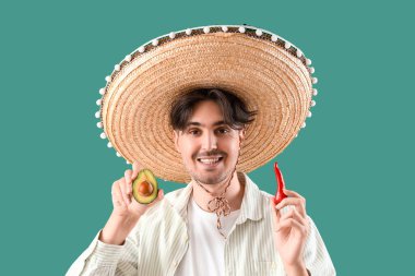 Kırmızı biberli genç Meksikalı adam ve yeşil arka planda avokado.