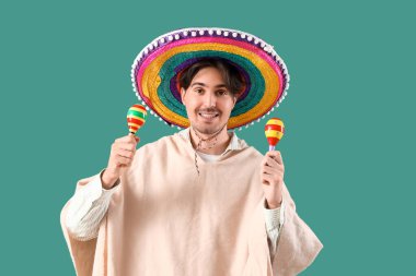 Yeşil arka planda marakas olan genç Meksikalı adam.