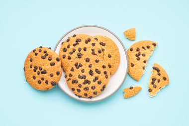 Mavi arka planda çikolata parçacıklı lezzetli kurabiyeler.