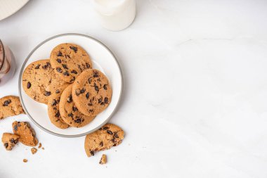 Beyaz arka planda çikolata parçacıklı lezzetli kurabiyeler.