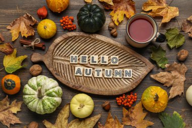 Tahta, balkabağı, çay, yaprak ve metin bileşimi Kahverengi ahşap arka planda Hello AUTUMN