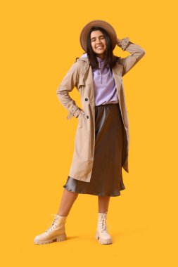 Sarı arka planda şık bir kapüşonlu güzel genç kadın.