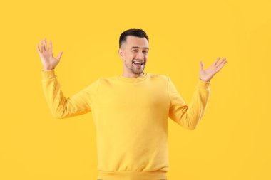 Sarı arka plandaki mutlu genç adam