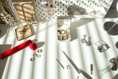 Atölyedeki kuyumcu masasında aletleri olan şık aksesuarlar.