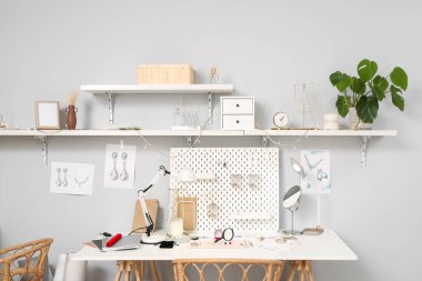 Atölyedeki kuyumcu masasında aletleri olan şık aksesuarların çizimleri.