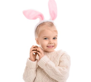 Beyaz arka planda çikolata yumurtası olan tavşan kulaklı mutlu küçük kız. Paskalya kutlaması