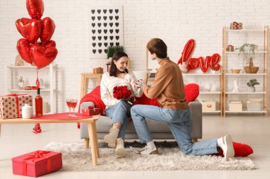 Genç adam evdeki sevgili kız arkadaşına evlenme teklif ediyor. Sevgililer Günü kutlaması