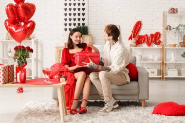 Genç adam sevgilisini sevgililer gününde evde karşılıyor.