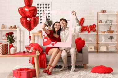 Çerçeveli genç bir çift evde selfie çekiyor. Sevgililer Günü kutlaması