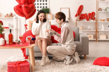 Genç adam evdeki sevgili kız arkadaşına evlenme teklif ediyor. Sevgililer Günü kutlaması