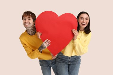 Beyaz arka planda kağıt kalpli genç bir çift. Sevgililer Günü kutlaması