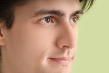 Yeşil arka planda kahverengi gözlü genç adam, yakın plan. Glaucoma farkındalık ayı