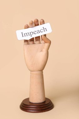 Bej arka planda IMPEACH sözcüğüyle tahta el