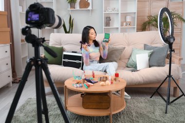Kadın Asyalı güzellik blogcusu, evinde video kaydediyor.