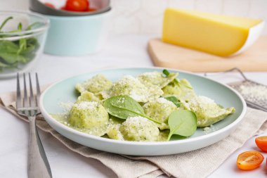 Beyaz zemin üzerinde peynir olan lezzetli bir ravioli tabağı.