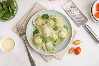 Beyaz zemin üzerinde peynir olan lezzetli bir ravioli tabağı.