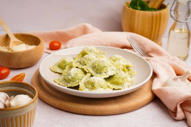 Beyaz zemin üzerinde peynir olan lezzetli bir ravioli tabağı.