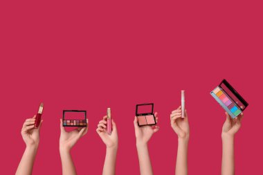 Göz falı olan kadın elleri ve koyu kırmızı arka planda ruj izleri.