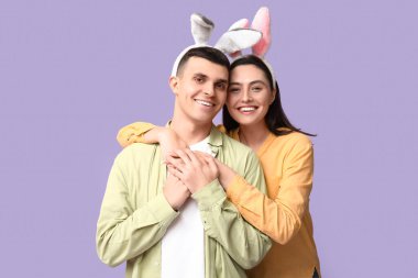 Leylak arka planında Paskalya tavşanı kulaklı mutlu genç çift