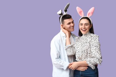 Leylak arka planında Paskalya tavşanı kulaklı mutlu genç çift