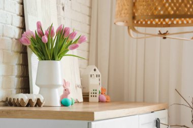 Laleli vazo, oyuncak tavşan ve oturma odasında Paskalya yumurtası.