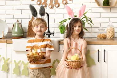 Evde paskalya yumurtası dolu sepetleri olan tavşan kulaklı şirin çocuklar.