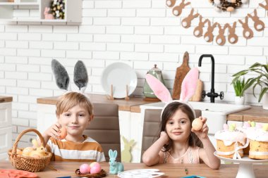 Evde boyalı Paskalya yumurtaları olan tavşan kulaklı şirin çocuklar.