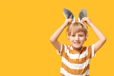Sarı arka planda tavşan kulaklı şirin bir çocuk.