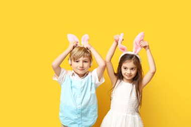Sarı arka planda tavşan kulaklı şirin çocuklar.