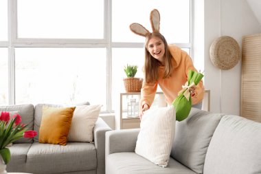 Tavşan kulaklı genç kadın evde Paskalya hediyesi yumurtası buldu.