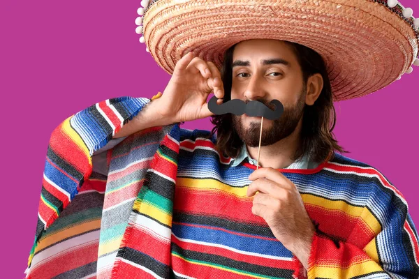 Sombrero, panço ve fonda kağıt bıyıklı yakışıklı Meksikalı genç adam.