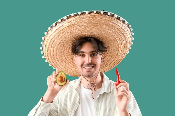 Kırmızı biberli genç Meksikalı adam ve yeşil arka planda avokado.