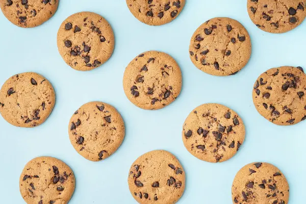 Mavi arka planda çikolata parçacıklı lezzetli kurabiyeler.