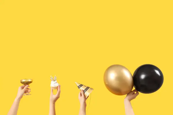 Vrouwelijke Handen Met Ballonnen Glas Cupcake Feestkegel Gele Achtergrond — Stockfoto